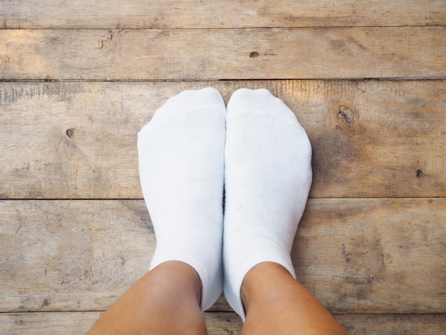 pies con calcetines blancos en madera