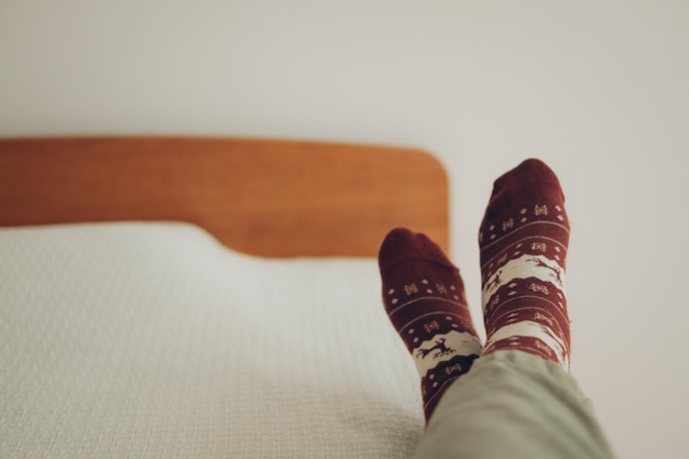 pies en calcetines con un estampado navideño en una cubierta de cama blanca