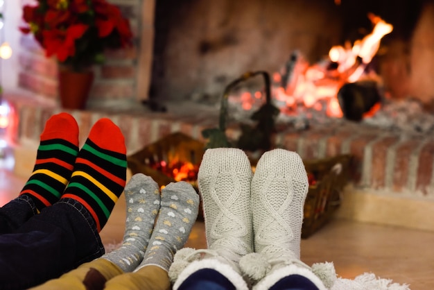 Pies con calcetines de navidad cerca de una chimenea