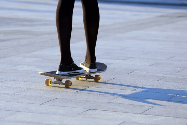 Pies chicas patinando en la ciudad.