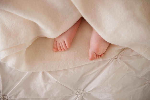 Pies y dedos de los pies del bebé o manta en la cama para el desarrollo de la infancia o la guardería dormir relajarse o descansar bienestar del niño y cuidado de los niños como primer plano para el bienestar siesta o soñar nutrir cuidado o calma