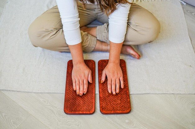 Los pies desnudos de las mujeres en una tabla con clavos para la práctica