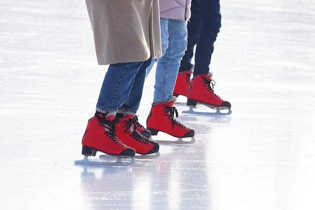 Pies de diferentes personas patinando en la pista de hielo.