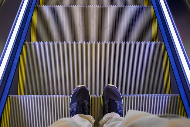 Pies en la escalera mecánica