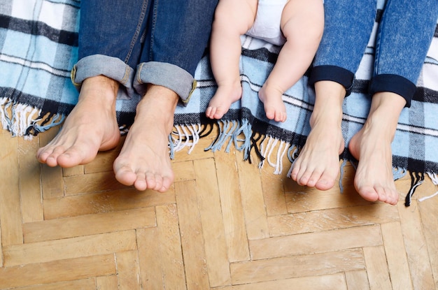 Foto pies de una familia joven de tres en el suelo