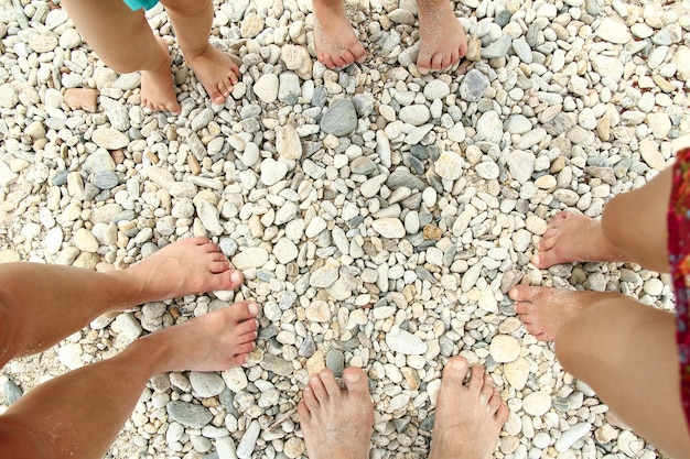 Pies familiares en la arena de la playa en verano