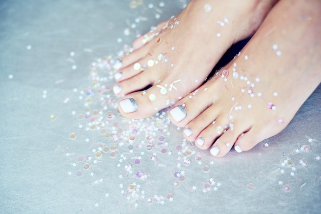 Pies femeninos con pedicura coloreada.