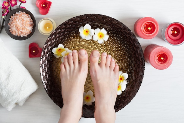 Pies femeninos en el procedimiento de pedicura de spa en el salón de belleza