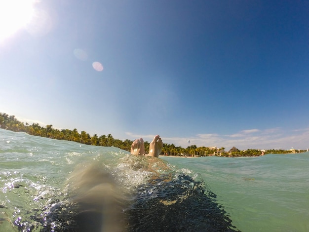 pies flotando en el agua del caribe