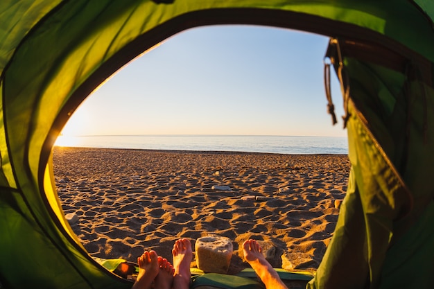 Foto pies fuera de una tienda con vistas a la orilla del mar