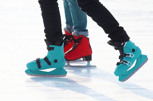 Pies de gente patinando en una pista de hielo en la calle. Deporte y entretenimiento. Descanso y vacaciones de invierno.