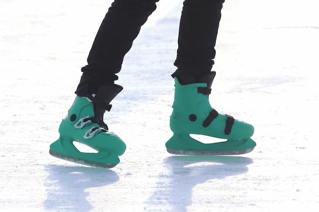 Foto pies de gente patinando en la pista de hielo.