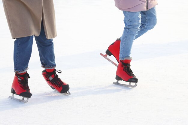 Pies de gente patinando en una pista de patinaje sobre hielo en la calle