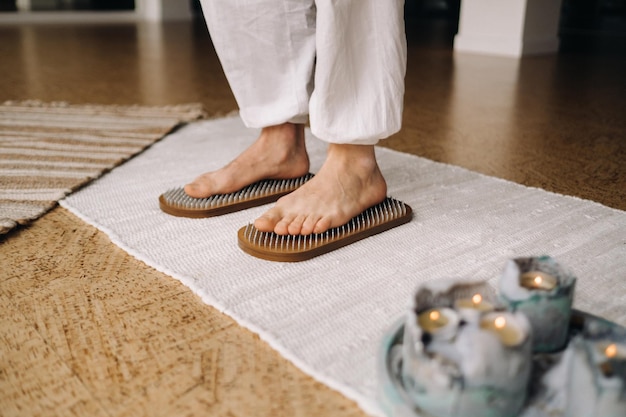 Los pies del hombre están junto a tablas con clavos Clases de Yoga