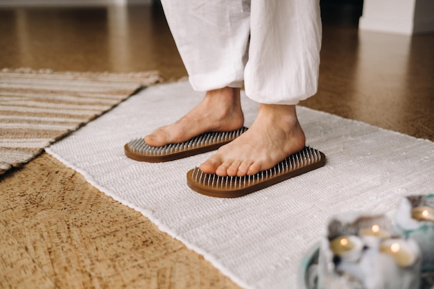 Los pies del hombre están junto a tablas con clavos Clases de Yoga