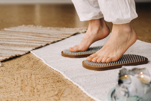 Los pies del hombre están junto a tablas con clavos Clases de yoga