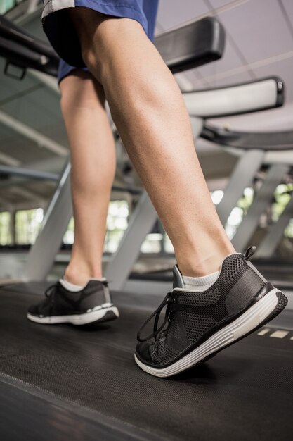 Los pies del hombre mientras camina en la fábrica de hilos