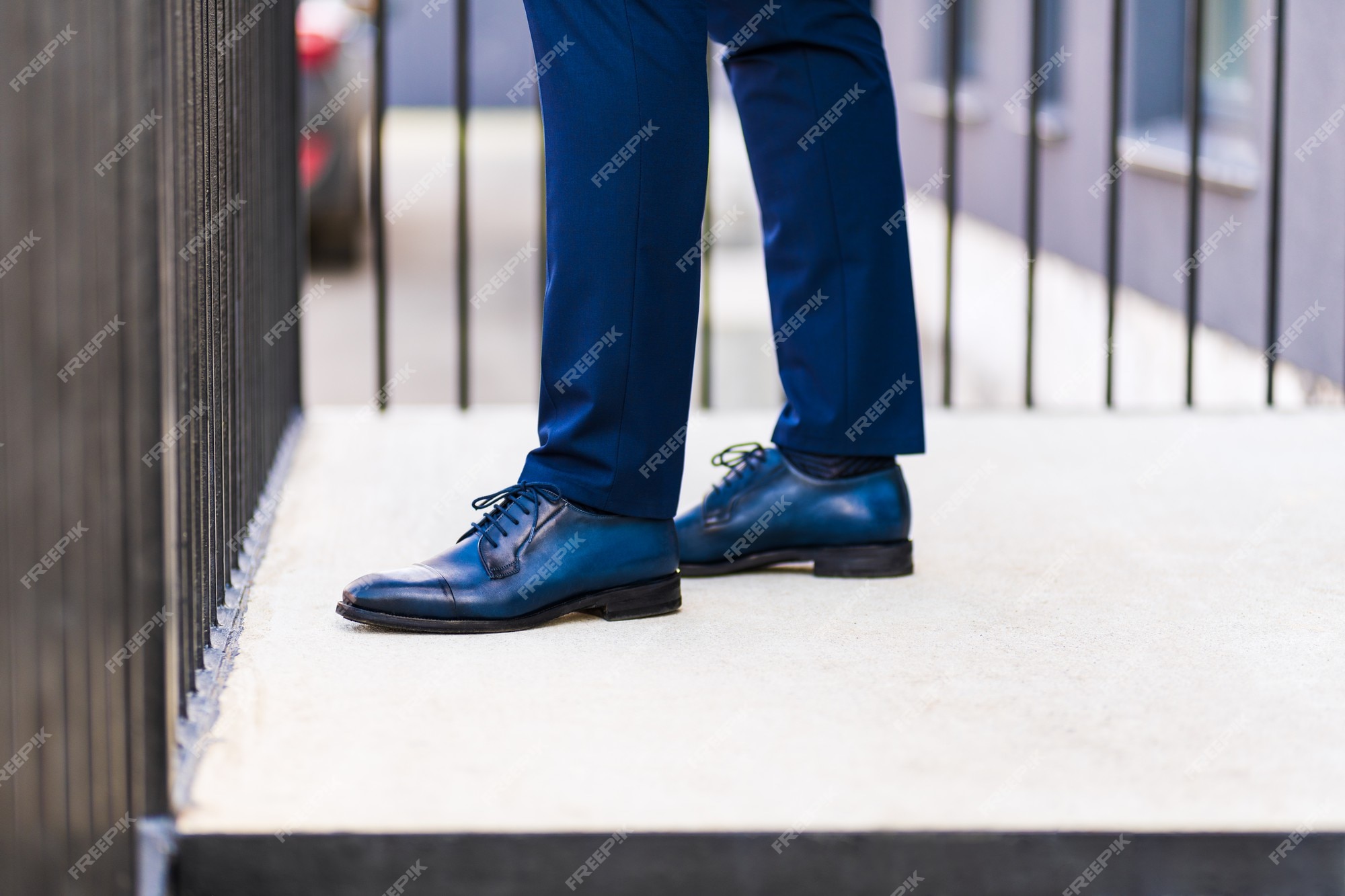 Pies de hombre con traje azul y zapatos en el porche de una casa en la calle. | Foto Premium