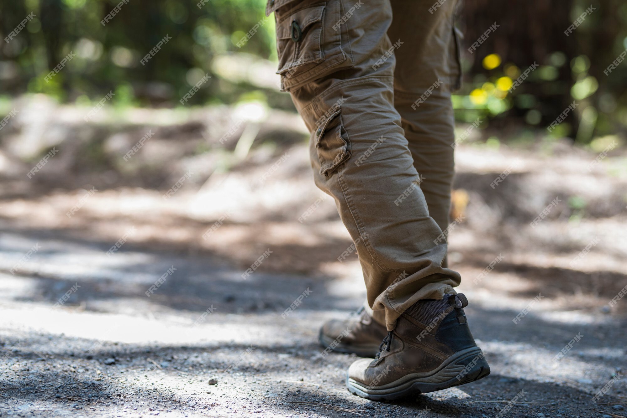 Pies de hombre con zapatos de senderismo caminando por el sendero del en verano, hombre caminando por la senda. bajo la sección de hombres caminatas en zapatos en sendero accidentado