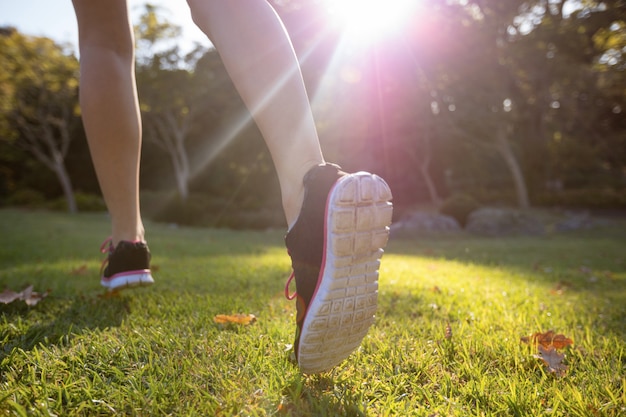 Pies de jogger corriendo en el parque