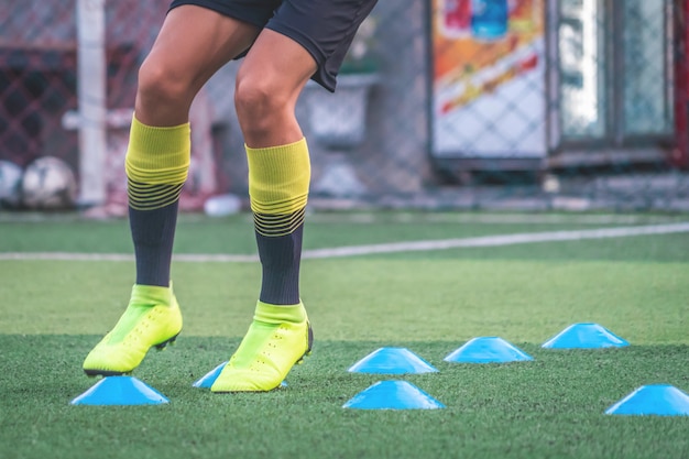 Los pies del jugador de fútbol entrenan con marcador en la academia