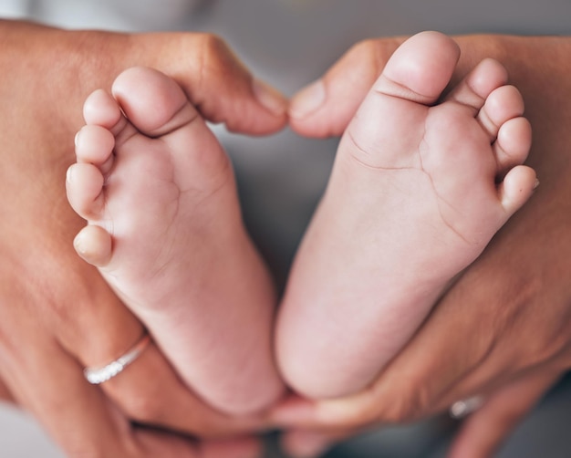 Pies y manos de bebé de la madre primer plano con recién nacido para el cuidado del amor o vínculo familiar en su hogar Zoom mamá y pie del bebé para la protección de la maternidad o el desarrollo infantil maternidad y cuidado