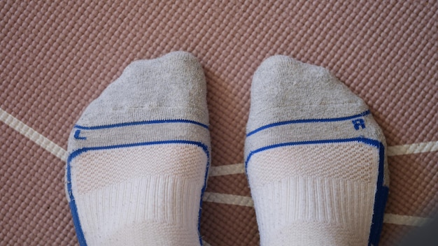 Pies masculinos en calcetines de pie en la estera de yoga primer plano vista superior concepto de entrenamiento deportivo en casa