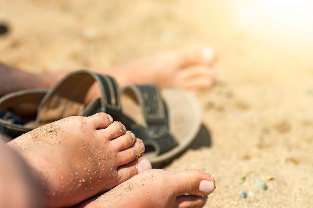 Pies de mujer en la arena de la playa.