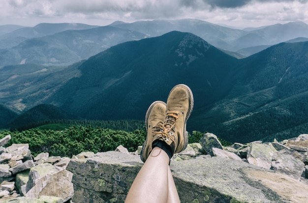 Pies Mujer botas de trekking relajantes al aire libre Viajes Mujer joven piernas calzadas en botas al aire libre