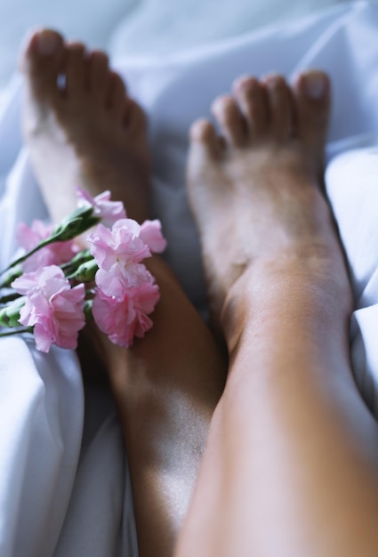 Pies de mujer en una cama blanca