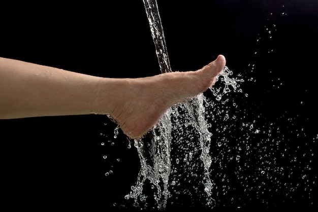 Foto los pies de la mujer con salpicaduras de agua