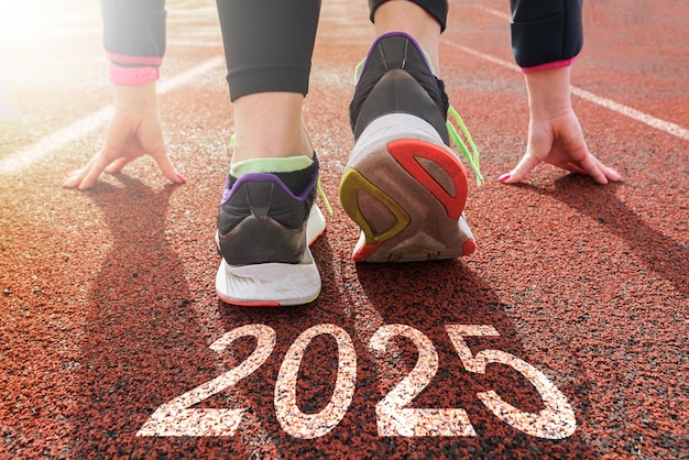 Los pies de las mujeres en la carretera corren el comienzo del Año Nuevo 2025