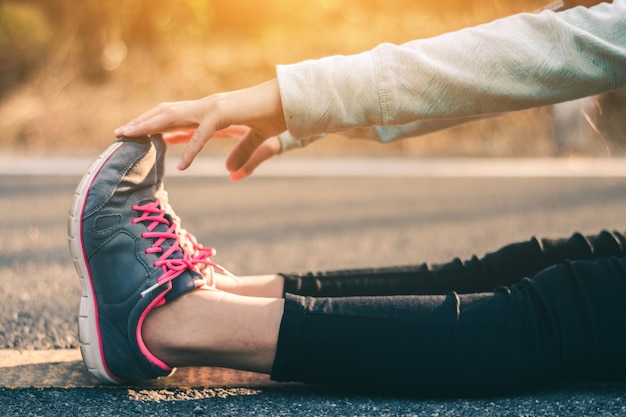 Foto pies de mujeres corredor en carretera en concepto de bienestar entrenamiento.