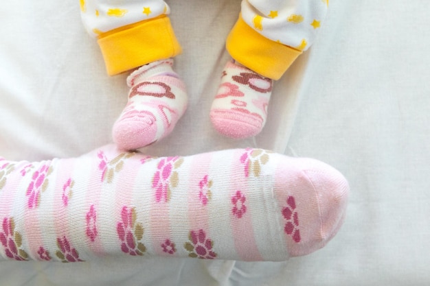 Pies de niña junto al pie de mamá con calcetines a juego