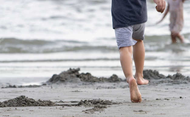 Pies de niño corriendo en una playa de arena