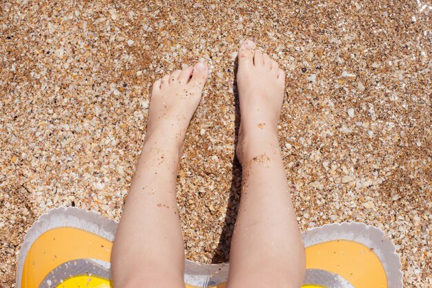 Foto pies de niño sobre la arena. descanso e infancia. aire de mar.