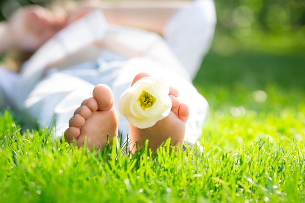 Pies de niños con flor de primavera sobre hierba verde