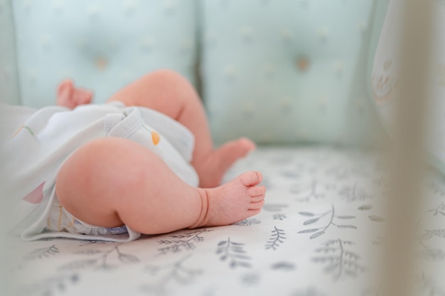 Los pies de los niños pequeños yacen sobre la colcha. Lindo concepto de recién nacido