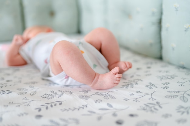 Los pies de los niños pequeños yacen sobre la colcha. Lindo concepto de recién nacido