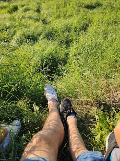 Pies de papá e hijo en la hierba en el parque