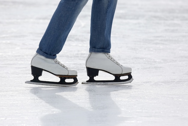 Pies patinaje niña patinando sobre pista de hielo