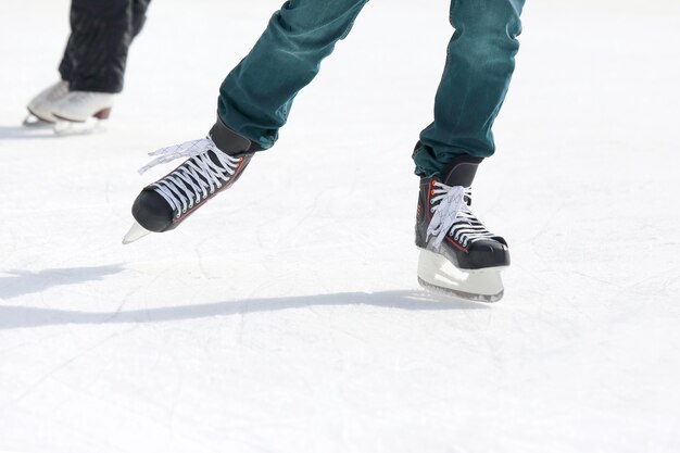 Pies patinando en la pista de hielo. Deporte y entretenimiento. Descanso y vacaciones de invierno.