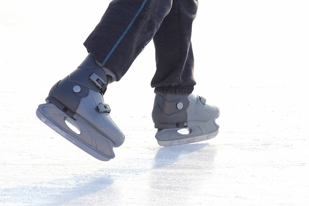 Foto pies patinando en la pista de hielo