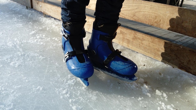 Pies con patines Equipos y uniformes deportivos Pista de hielo Largas sombras sobre el hielo del bajo sol de invierno