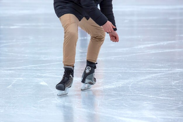 Pies en los patines de una persona que rueda en la pista de hielo