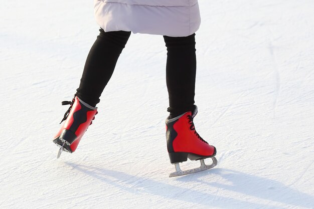 Pies en patines rojos sobre una pista de hielo