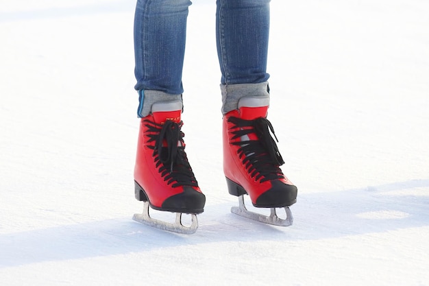 Pies en patines rojos sobre una pista de hielo