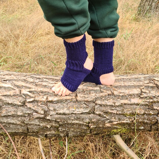 Los pies de una persona sobre un tronco.