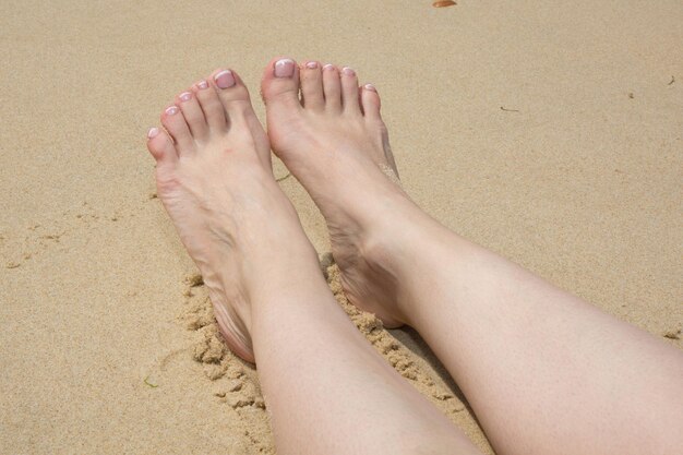Pies en la playa en verano