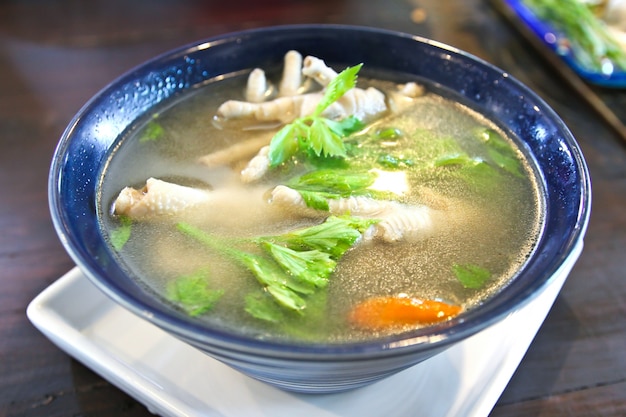 Pies de pollo en un cuenco con sopa picante, comida tailandesa